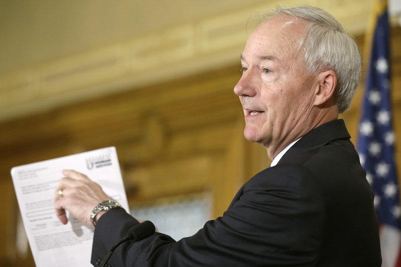 Arkansas Gov. Asa Hutchinson points out details on a Medicaid form at the Arkansas state Capitol in Little Rock, Ark., Tuesday, Aug. 4, 2015. 