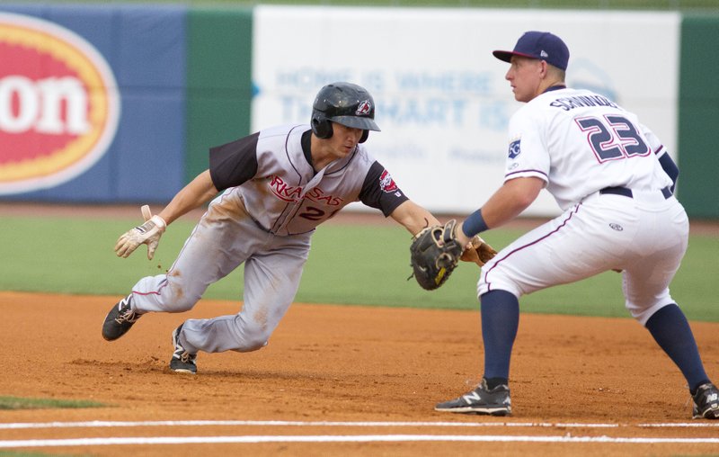 Special to NWA Democrat-Gazette/DAVID J. BEACH Chad Hinshaw of the Travelers dives back to first base Tuesday during the first inning as the Naturals&#8217; Frank Schwindel is about to take the ball at Arvest Ballpark in Springdale.
