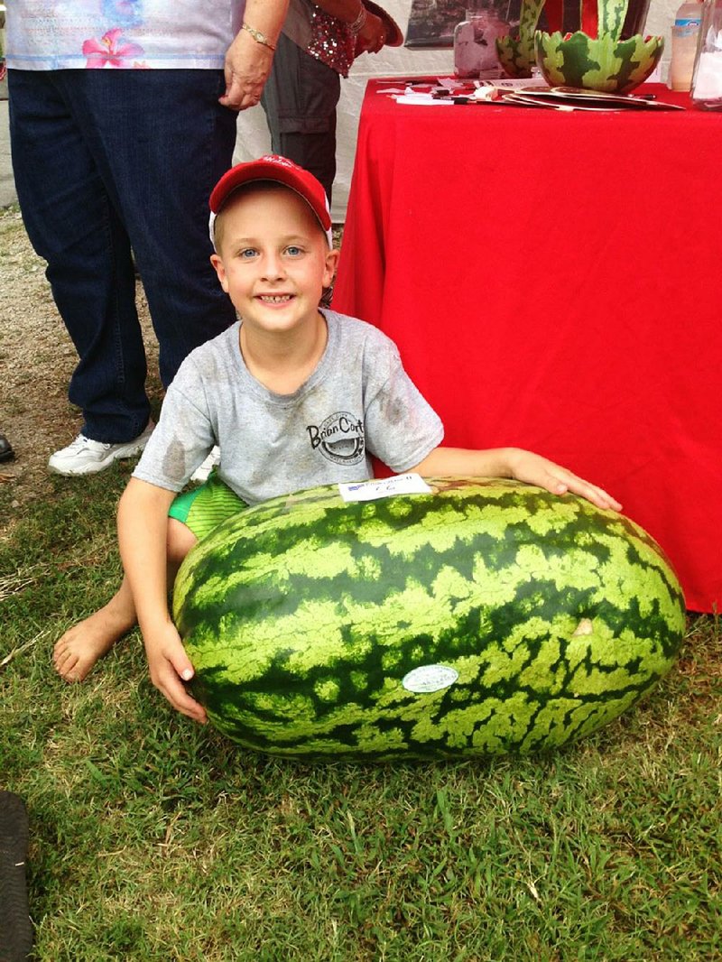 Bricen Carter poses with his prize-winning 86-pound melon at last year’s Cave City Watermelon Festival.

