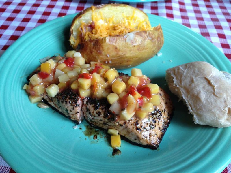 “Surf” at Fresh: An Urban Eatery is a 4- or 8-ounce salmon plank topped with mango salsa, plus a baked potato and an artisanal roll.