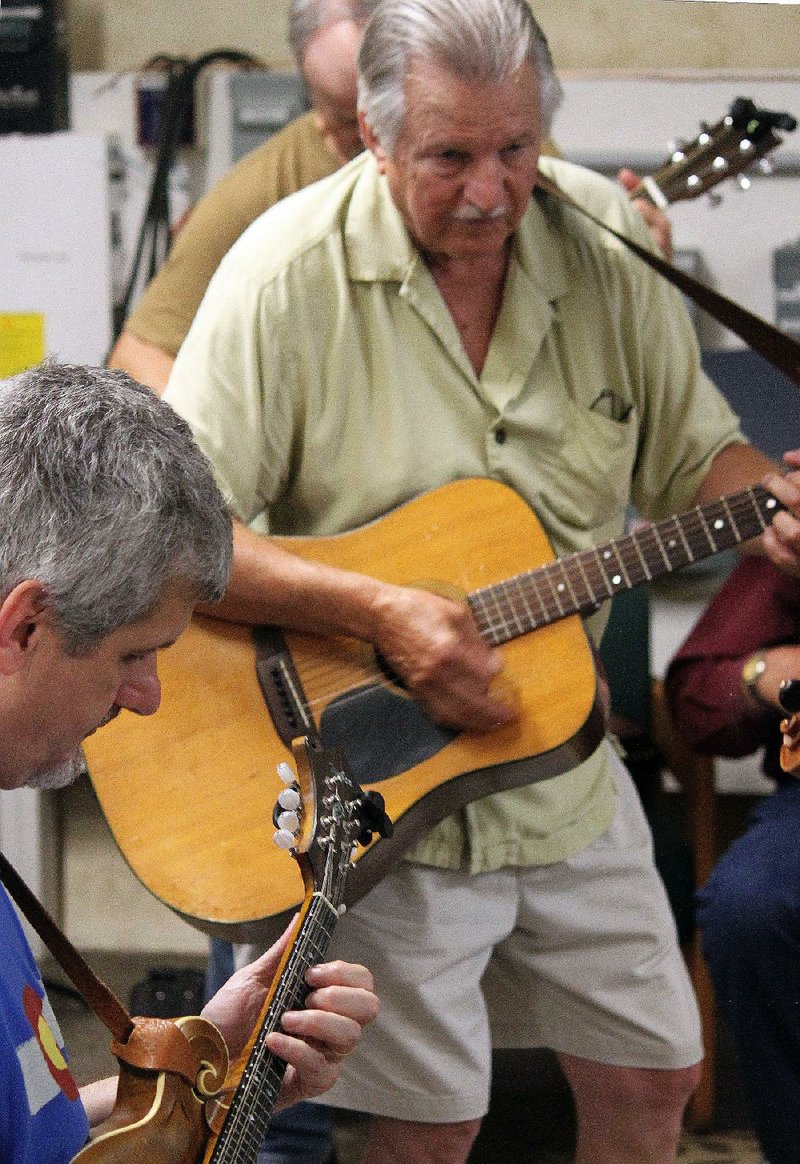 Larry Cross on mandolin and Charlie Teas on guitar strum up a storm at the annual picnic of the Rackensack Folklore Society in June.