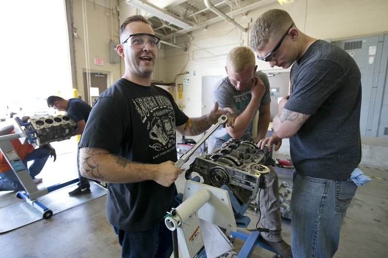 In this Thursday, June 18, 2015 file photo, from left, Sgt. Garret Baganz, Spc. Tyler Sonsoucie and Spc. Ian Sokol work on a ecotech engine during an automotive skills class at Fort Hood, Texas.