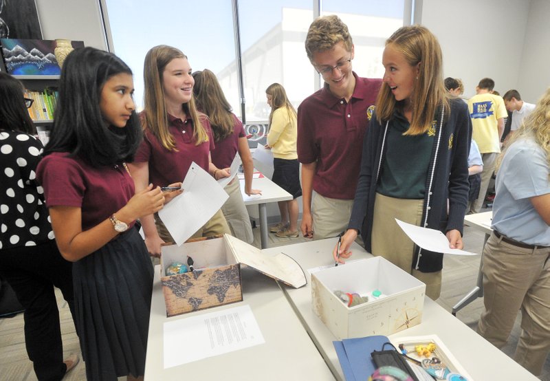 Haas Hall Academy students Rumaanah Sharif, (from left) Emma Cheatham, Gabe Lovatt-Sutton and Caroline Crank talk Friday as they critique each other’s projects during a class activities at the new Bentonville campus. Classes at the new campus started Thursday.