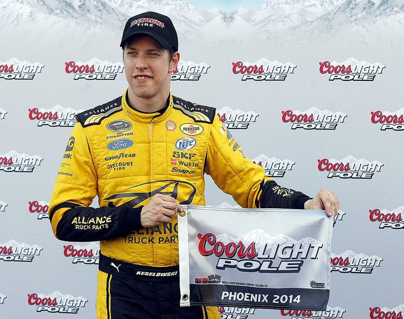 Brad Keselowski holds the flag after winning the pole for Sunday's NASCAR Sprint Cup Series auto race, Friday, Feb. 28, 2014, in Avondale, Ariz.