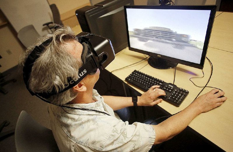 Malcolm Williamson, a research associate with the Center for Advanced Spatial Technologies at the University of Arkansas at Fayetteville, demonstrates virtual reality technology July 31. 