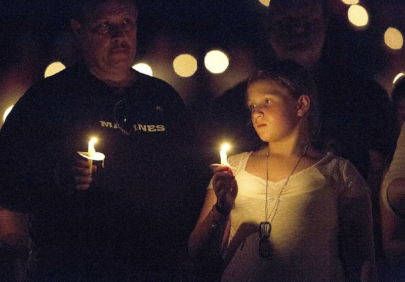 Rebecca Wyatt holds a candle Friday during a vigil for her father Staff Sgt. David Wyatt in Russellville. The Marine was one four military personnel killed in Chattanooga in late July.