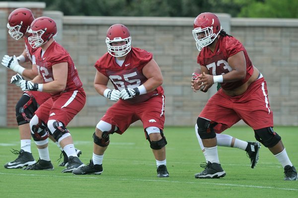 Arkansas players Dan Skipper (70) Frank Ragnow (72) Mitch Smothers (65) and Sebastian Tretola (73) line up to run a play during the Arkansas Razorbacks' practice Thursday, Aug. 6, 2015, in Fayetteville.