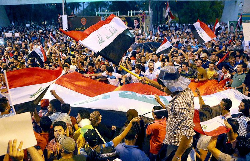 Iraqis rally in support of Iraqi Prime Minister Haider al-Abadi as they wave national flags during a demonstration at Tahrir Square in Baghdad on Sunday.