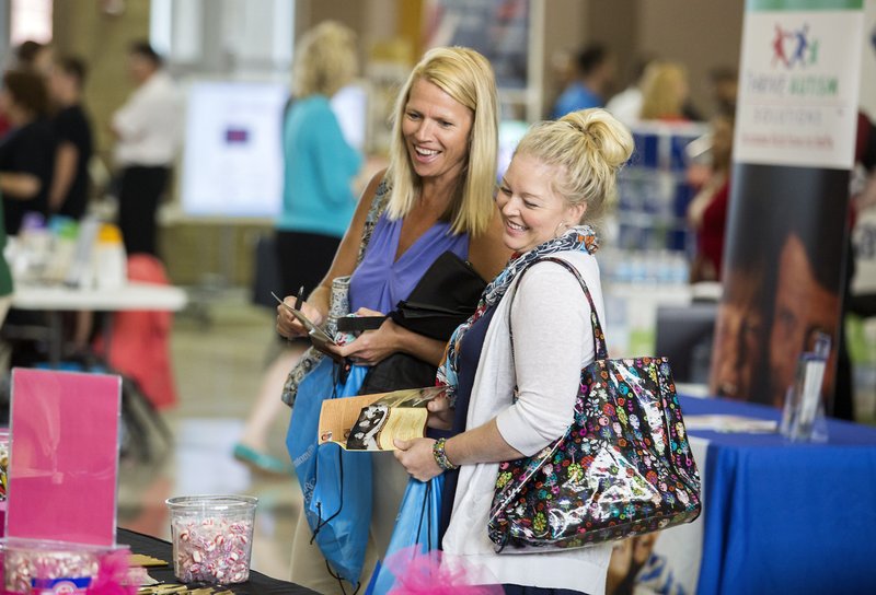 Kristy Bailey (left) and Becky Payne, both faculty members at Fulbright Junior High, peruse the Bentonville School District’s Teacher Fair Monday at Bentonville High School. The event, hosted by the Bentonville-Bella Vista Chamber of Commerce, featured 75 vendors for faculty and staff members throughout the school district. The Bentonville traditional classes start back Aug. 18. For more photos, go to www.nwadg.com/photos.