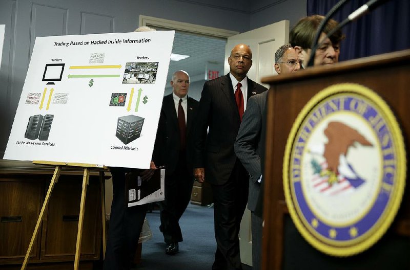 A poster detailing an insider trading scam is displayed Tuesday at the start of a news conference in Newark, N.J.