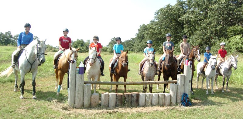 Photo by Mike Eckels Members of the Legends Equestrian Center&#8217;s advanced riding class stopped for a short break after riding from Decatur to the Horses for Healing facility near Bentonville July 30. The riders include Heather Swope (left), instructor, on Piper; Ellie Toothaker on Iris; Zoe Kendrick on Diego; Marguerite Johnson on Canela; Alyx Swope-Bell on Dottie; Jordan Cook on Beauxsoleil; Alexis MacFarlane on Gunner; Bryn Swope-Bell on Stormy; and Emma Johnson on Diva.