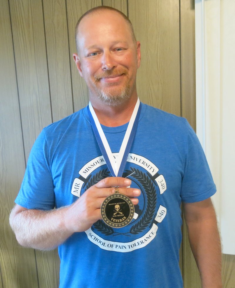 Photo by Susan Holland Michael Williams, of Gravette, displays the medal he won for completing the Missouri 340, the world&#8217;s longest river race, in the allotted time. Michael and his teammate, Henri Coeme of Neosho, Mo., completed the four-day race in 77 hours, 37 minutes. They competed under the name the River Zombyes and raised money for the Gravette Public Library.