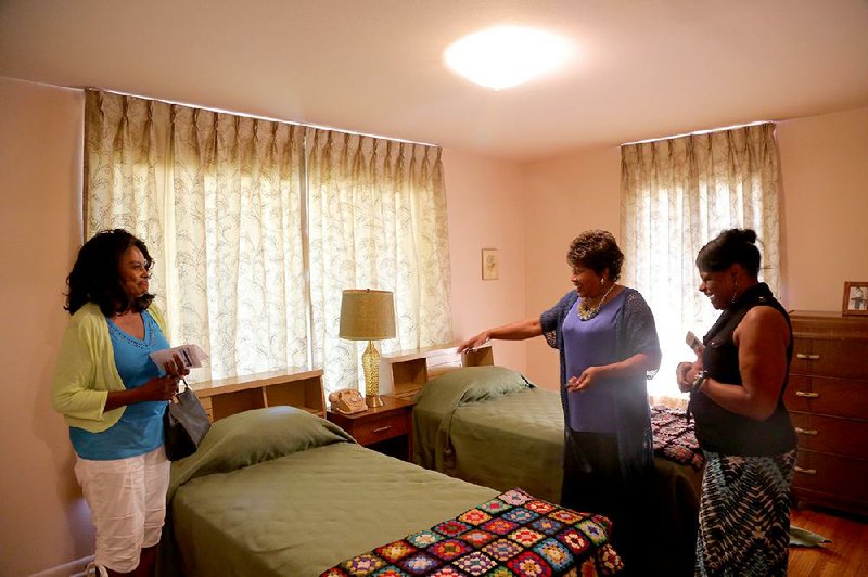 Mary Hardin (center) gives a tour of the home of Daisy Gatson Bates on Wednesday to guests Delores Paul (left) of Little Rock and Charleszella Mikel of Jackson, Miss.