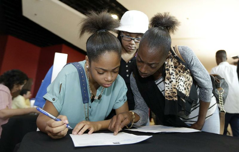 Job seekers complete applications at a job fair in Sunrise, Fla., in June. Total hiring increased 2.3 percent to 5.18 million in June, the Labor Department said Wednesday.