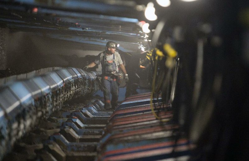 A miner walks under hydraulic jacks next to a coal seam in Foresight Energy’s Pond Creek mine in Johnson City, Ill., in this file photo.