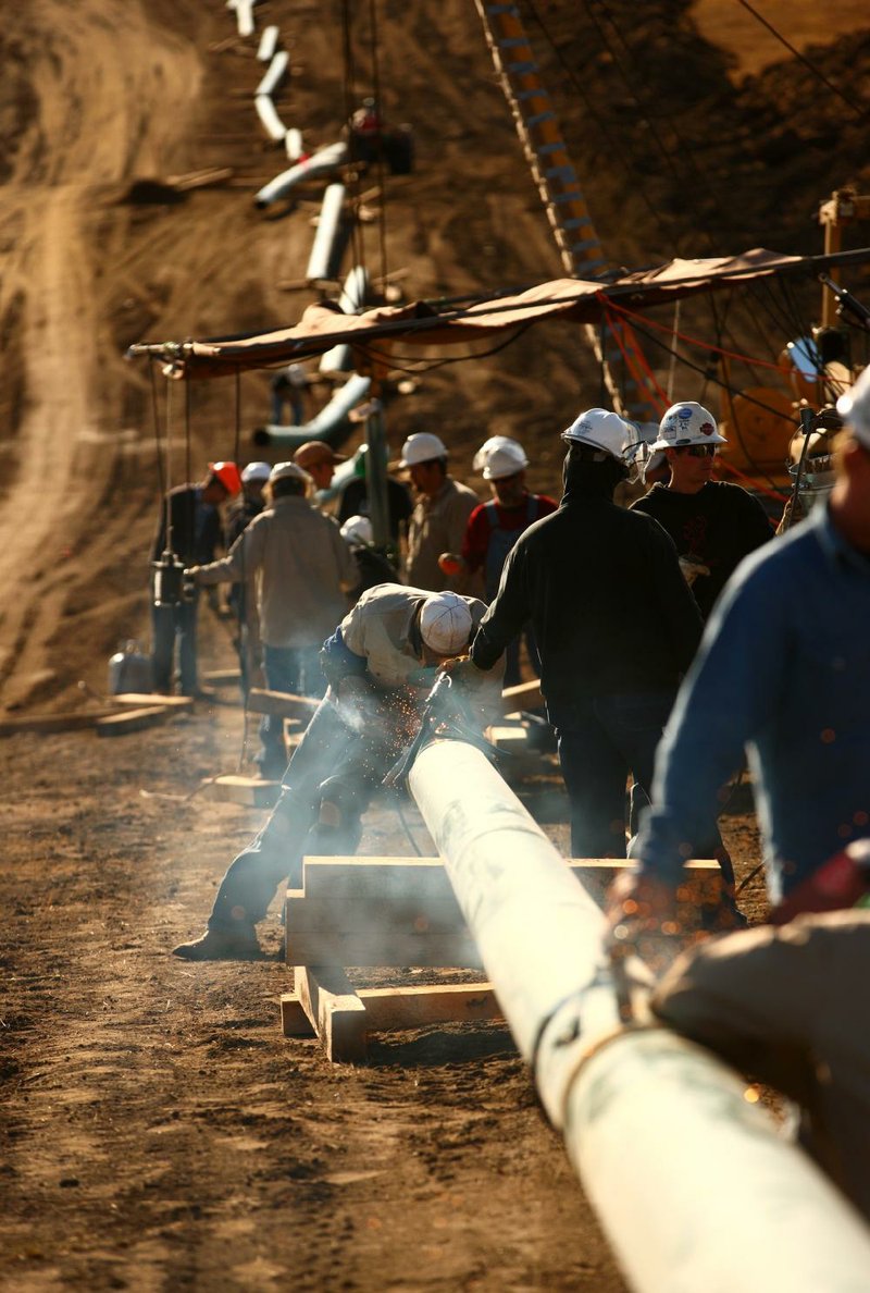 A crew from Alpha Oil & Gas Services Inc. works on a 10-inch gas pipeline near Watford City, N.D., in this file photo. Some of North Dakota’s Bakken shale drillers say they continue profit despite lower oil prices. 