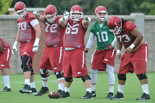 Arkansas offensive linemen Dan Skipper (70), Frank Ragnow (72), Mitch Smothers (65) and Sebastian Tretola (73) line up front of quarterback Brandon Allen (10) during practice Thursday, Aug. 6, 2015, in Fayetteville. 