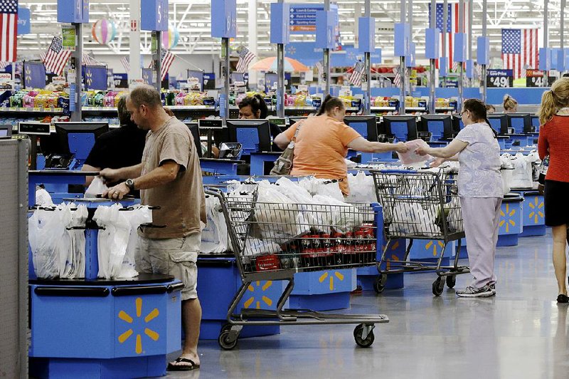 Shoppers check out at a Wal-Mart Supercenter store in Springdale in June. Retailers reported stronger sales in July, the Commerce Department said Thursday.