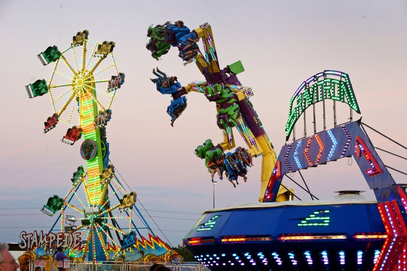 Rides spin into the evening during the Benton County Fair at the Benton County Fairgrounds & Expo Center in Bentonville. 