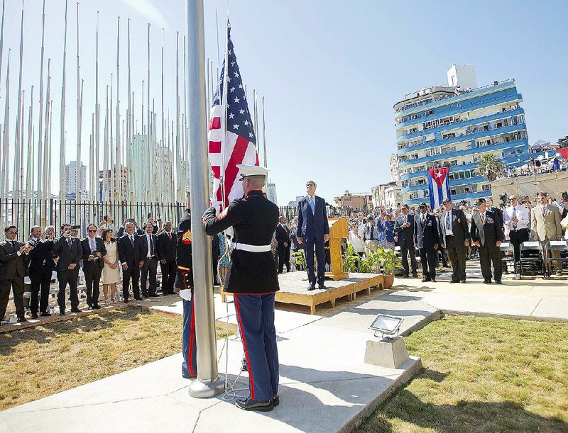 Secretary of State John Kerry and other dignitaries watch Friday as Marines raise the flag over the newly reopened U.S. Embassy in Havana.