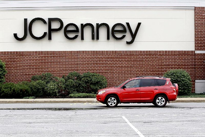 A car crosses a parking lot outside a JC Penney store at the Hanover Mall in Hanover, Mass., last month. The department store lost $138 million, or 45 cents per share, in the quarter that ended Aug. 1. 