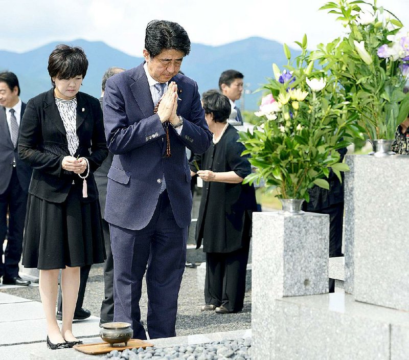 Japanese Prime Minister Shinzo Abe, accompanied by his wife, Akie, prays at his ancestors’ grave in Nagato, western Japan, on Friday. 