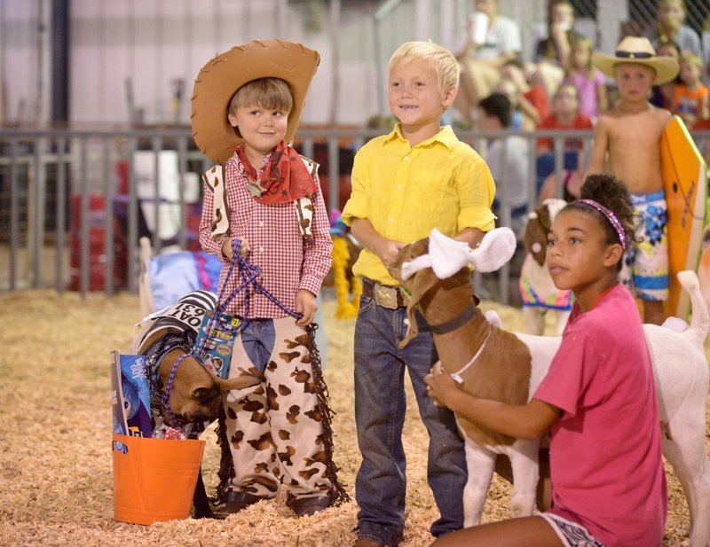 Jasper Schaffer, 4, (from left) of Gravette with goat Bow, dressed as a western sheriff and prisoner, and Braxten Pembleton, 7, of Gravette take part in the goat costume contest Friday at the Benton County Fair. For more photos, go to www.nwadg.com/photos.