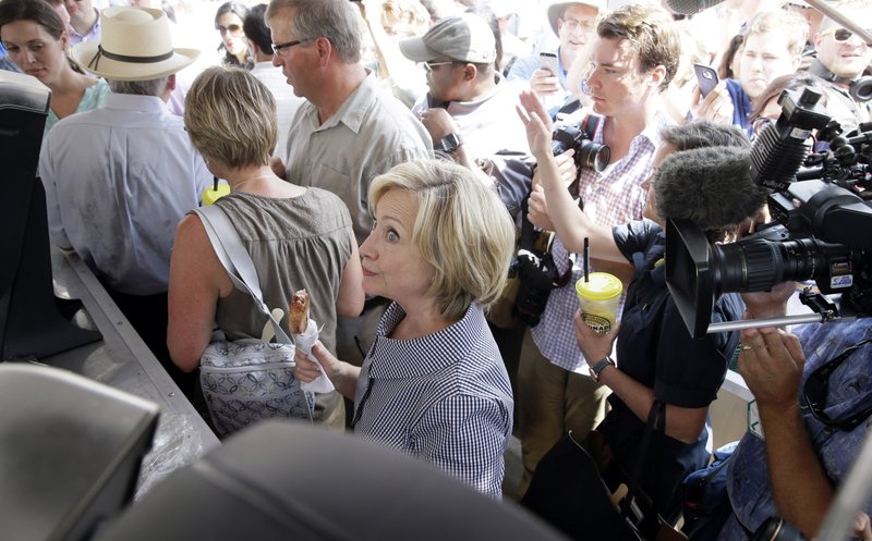 Democratic presidential candidate Hillary Rodham Clinton leaves a pork chop stand during a visit to the Iowa State Fair, Saturday, Aug. 15, 2015, in Des Moines, Iowa. 