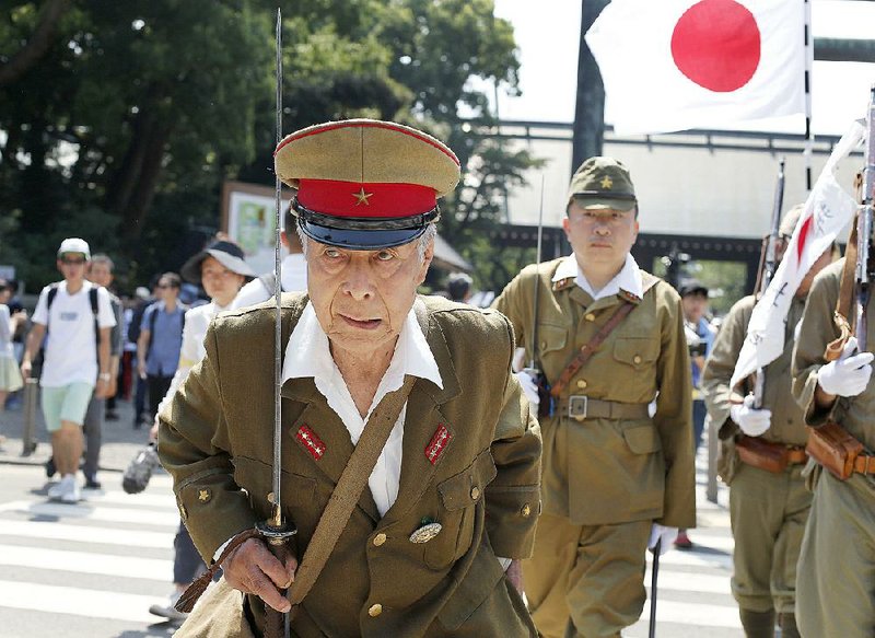 Japanese men dressed in old military uniforms march Saturday to pay their respects to the country’s war dead at the Yasukuni shrine in Tokyo. Japan on Saturday marked the 70th anniversary of the end of World War II. 