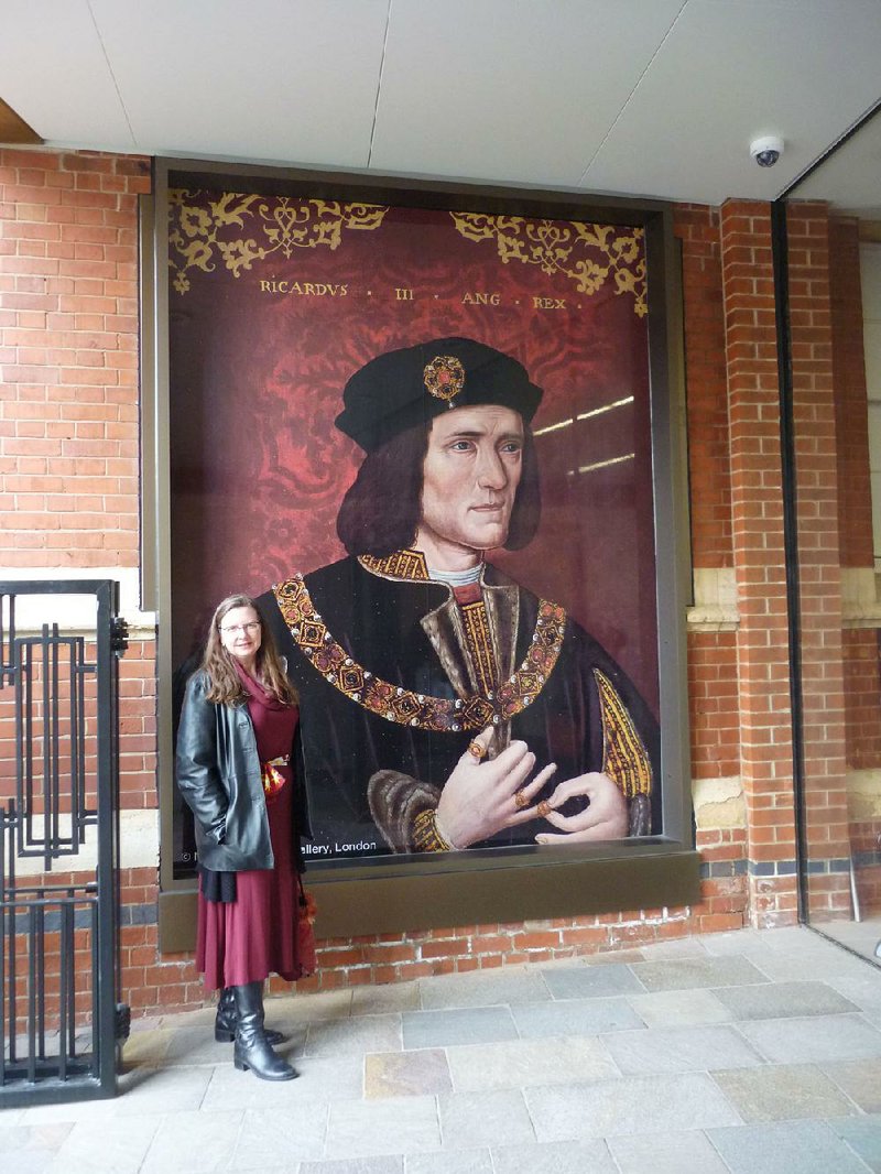 Hendrix College faculty member Karen Griebling, composer of the opera "Richard III: A Crown of Roses, A Crown of Thorns," poses with a portrait of her “subject” on a visit to the British city of Leicester in March.