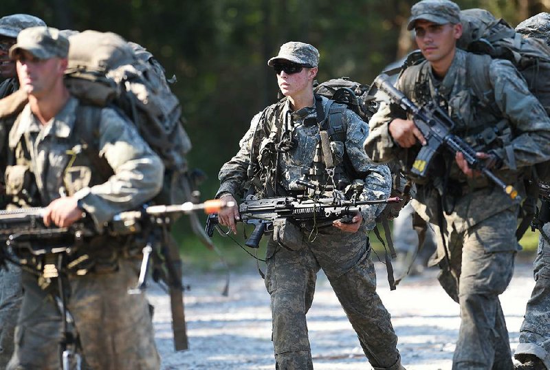 A female soldier (center) trains with her unit Aug. 4 at Army Ranger School at Eglin Air Force Base, Fla. All who graduate are required to meet the same rigorous physical, mental and technical standards. 