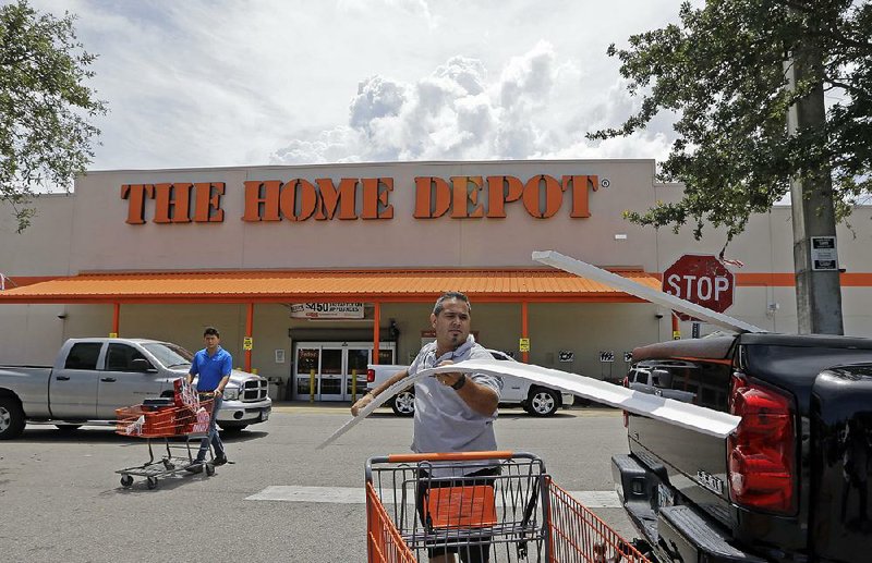 A Home Depot shopper loads garage door trim into his pickup in Hialeah, Fla., in July. The home improvement chain on Tuesday reported a quarterly profit of $2.23 billion.