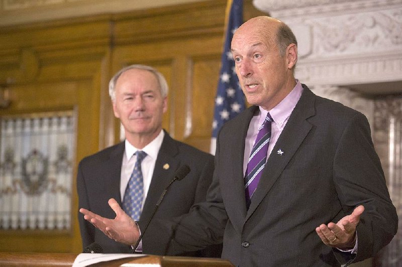 Gov. Asa Hutchinson and Department of Human Services Director John Selig discuss the resumption of Medicaid cancellation notices at the state Capitol in this August, 18 2015 photo.