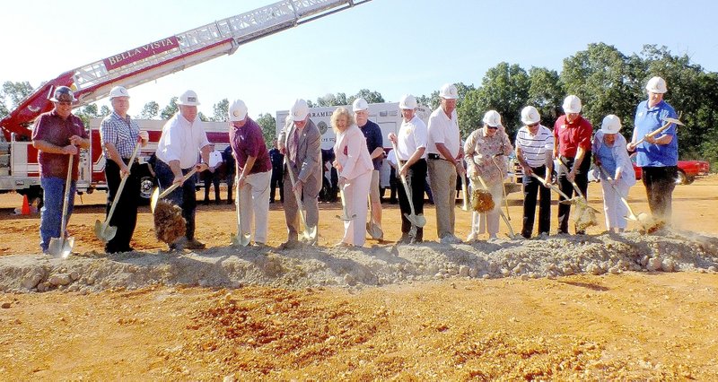 Brandon Howard/The Weekly Vista City officials, firefighters and residents toss dirt from golden shovels Thursday, August 13, to celebrate the groundbreaking of Bella Vista&#x2019;s fourth fire station. The Highlands Gate Station will stand at the intersection of Arkansas 279 and Buckstone Drive. The facility will be approximately 9,200 square feet and house between 9-12 firefighters, according to Fire Chief Steve Sims. Construction should begin in mid September with a tentative opening date set for spring 2016, Sims said.
