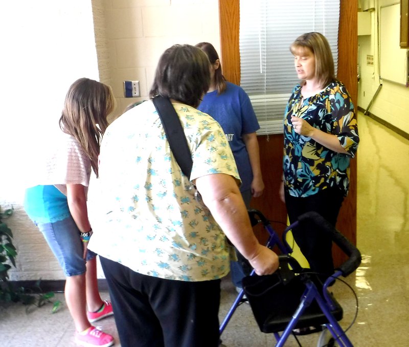 Photo by Mike Eckels Carol Owens (right) talks to family members as they wait to pick up a student packet during the Decatur Middle School open house Aug. 13.