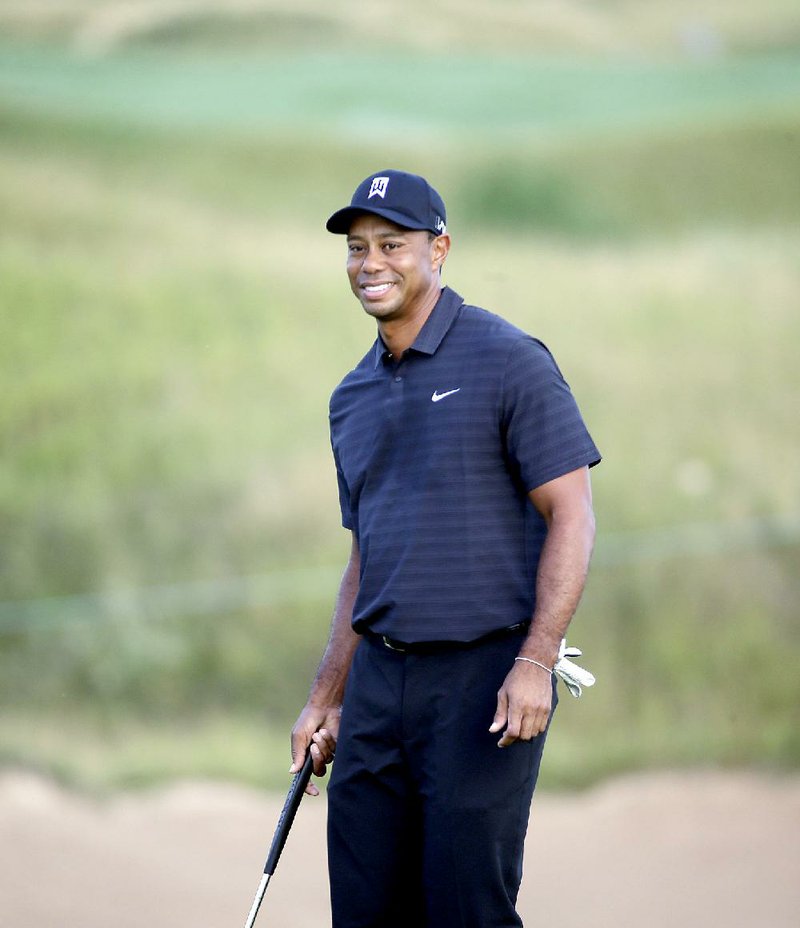 Tiger Woods smiles as he plays the 10th hole during a practice round for the PGA Championship golf tournament Wednesday, Aug. 12, 2015, at Whistling Straits in Haven, Wis. 