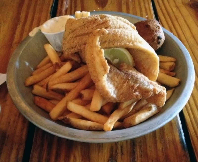 Fried catfish filets are served with French fries and a hush puppy at Cock of the Walk. 