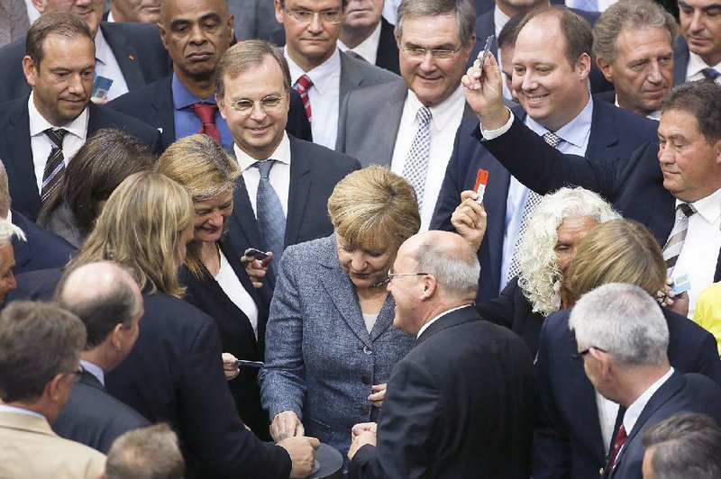 German Chancellor Angela Merkel (center), casts her vote Wednesday on a bailout package for Greece in the German parliament Bundestag in Berlin. 