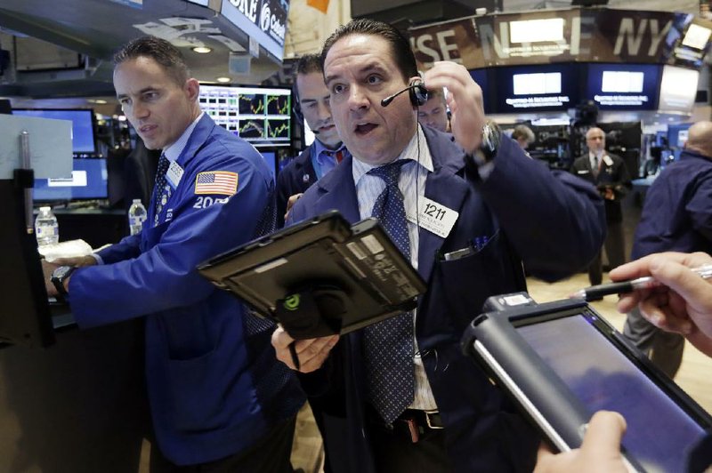 Trader Tommy Kalikas (right) works Thursday on the floor of the New York Stock Exchange.