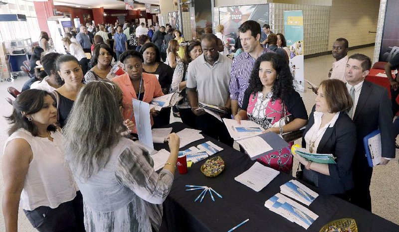 Job seekers collect information at a job fair in Sunrise, Fla., in June. Weekly applications for unemployment benefits rose by 4,000 last week to a seasonally adjusted 277,000, the Labor Department said Thursday. 
