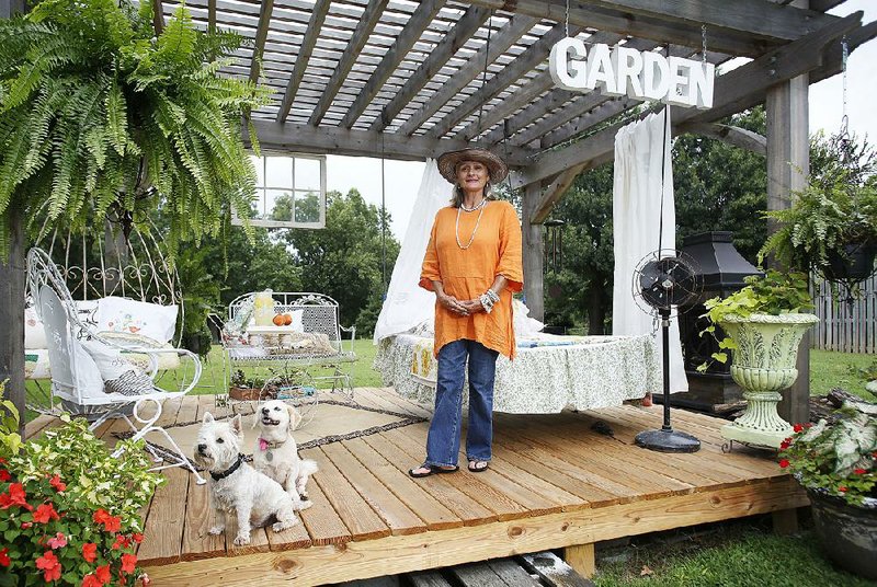 Suzanne Slinkard Lentz stands in her favorite personal space with her dogs, the decorated deck in the backyard of her Prairie Grove house Monday, August 10, 2015.