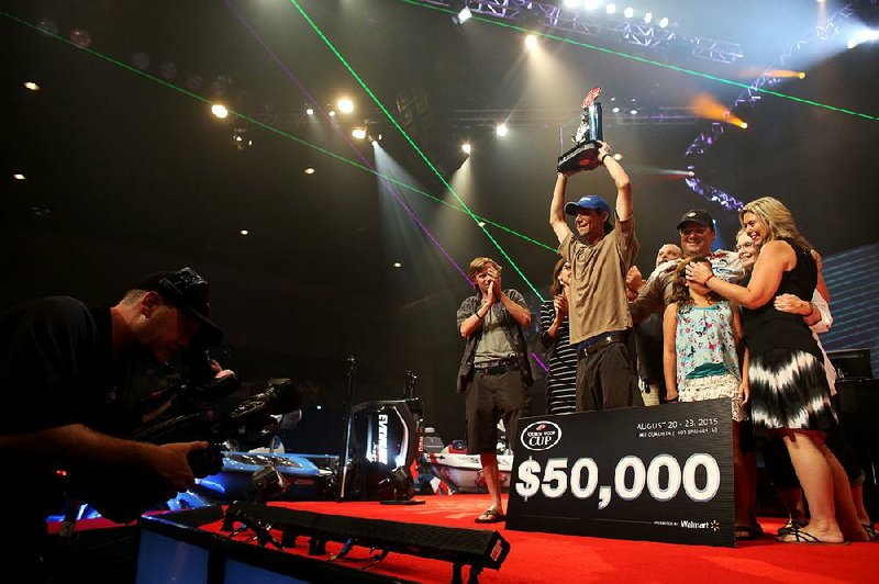 Sunny Hawk of Salt Lake City celebrates after winning the co-angler championship at the FLW Forrest Wood Cup on Friday at Bank of Ozark Arena in Hot Springs. Hawk’s title will the final one of its kind in the annual tournament.