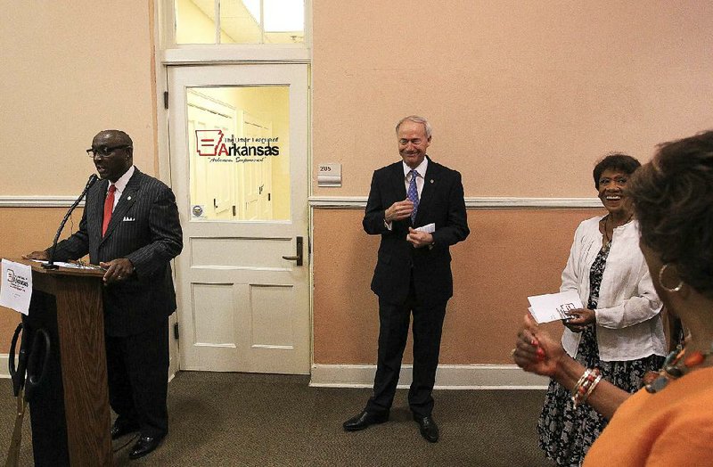 Sherman Tate, board chairman for the Urban League of Arkansas, speaks at the Willie L. Hinton Neighborhood Resource Center in Little Rock at a ceremony Friday to mark the renewal of the organization. Gov. Asa Hutchinson is at center.