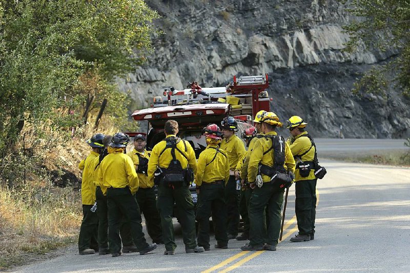 Firefighters from several King County agencies gather for a briefing Friday in Twisp, Wash. 