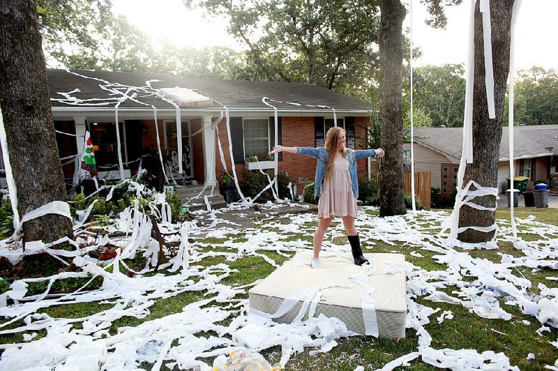 North Little Rock High School junior Claire Reid poses for a picture taken by her father (not shown) in her family’s front lawn Aug. 17. Claire had her traditional first-day-of-school portrait taken in front of a toilet-papered home after “Senior Roll Night.” Seniors “rolling” the homes of juniors has been tradition at the high school since the early 1990s.