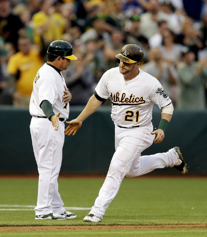 The Oakland Athletics fired third base coach Mike Gallego (left) on Sunday. Gallego, shown here congratulating Stephen Vogt for his home run on Aug. 6, was the A’s third base coach for the past seven seasons.
