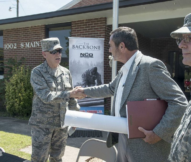 Berryville Mayor Tim McKinney (right) thanks Maj. Gen. Mark Berry at the end of a ceremony Tuesday at the Arkansas National Guard armory in Berryville. The Guard handed over ownership of the building to the city under a cost-saving plan approved by the governor in June.