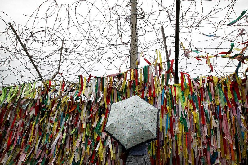 A visitor on Tuesday reads ribbons with messages wishing for the reunification of the two Koreas at the Imjingak Pavilion in Paju, South Korea, near the border village of Panmunjom.