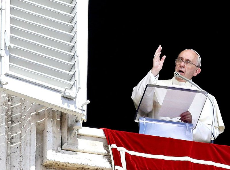 Pope Francis delivers his blessing Sunday during the Angelus noon prayer from the balcony of his apartment overlooking St. Peter’s Square at the Vatican.