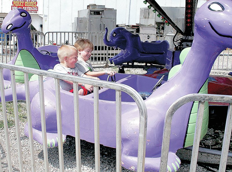 FILE PHOTO These children enjoy one of the many rides at the Washington County Fair midway in 2014. The 2015 county fair opens Tuesday with exhibits, livestock, food and carnival rides.